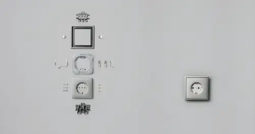 Steckdose aus Aluminium im Programm LS 990, in ihren Bestandteilen und zusammengebaut