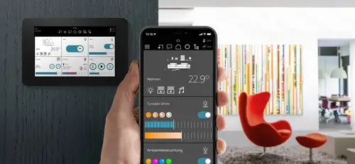 iphone mit der Smart Vision App zeigt die Fernsteuerung eines Smart Panel 8 im HIntergrund, Ambienteaufnahme in einem modernen Wohnbereich