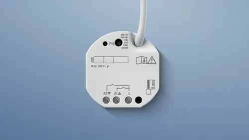 KNX Schalt- und Jalousieaktor vor blauem Hintergrund.