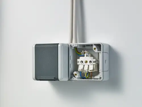 Tomada dupla SCHUKO® da gama WG 800, à esquerda com tampa, à direita com circuito visível para visualização. Fotografado de uma perspetiva ligeira.