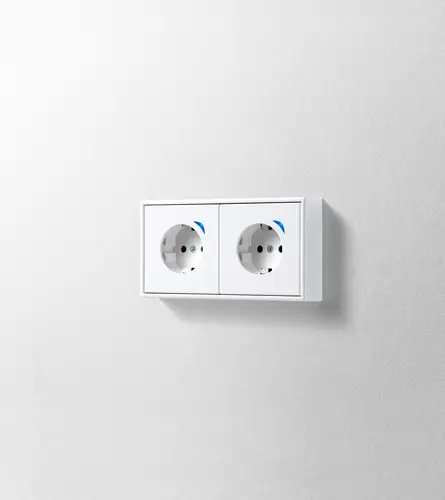 JUNG HOME SCHUKO® socket outlet 2-gang 28 mm installation height in the LS 990 range, white, detailed view in light perspective.