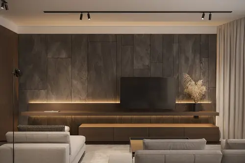Plug &amp; Light in black, taken in a home cinema furnished in natural and grey tones. A pleasant ambient light illuminates the wall behind the TV.