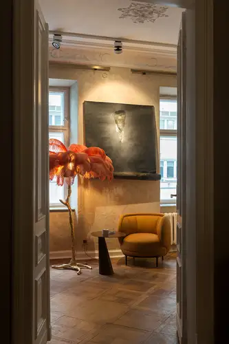 SCHUKO socket outlet, included in the room cut-out with a sophisticated interior and a floor lamp with pink feathers.