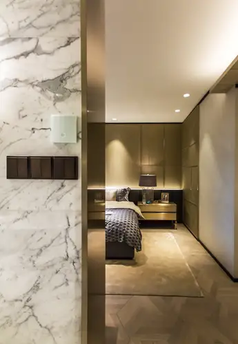 Series push-button in the LS 990 range in Dark, made of lacquered aluminium. Ambience shot in the Changfeng Residence, Shanghai. Shot in a passageway, with a modern bedroom in the background.