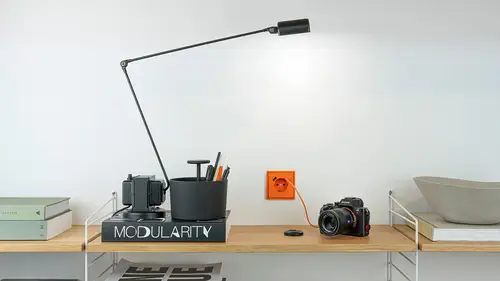 Steckdose mit USB-Anschluss im Programm LS 990 in Les Couleurs® Le Corbusier, LC-32080 orange. Frontalaufnommen mit einer Kamera im Vordergrund, welche geladen wird.