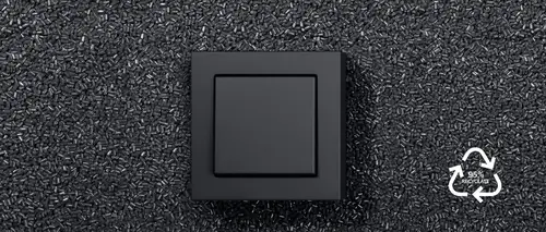 Pulsador de la gama A CUBE de plástico en antracita mate, recubierto hasta la mitad con material reciclado negro y el logotipo del 95% de material reciclado en blanco.