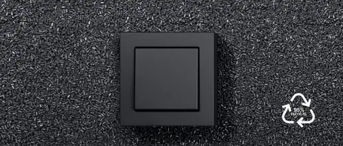Taster im Programm A CUBE aus Kunststoff in Anthrazit matt, zur Hälfte bedeckt von schwarzem Rezyklat und dem Logo für 95% recyceltes Rezyklat in weiß.