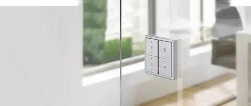 Funk-Wandsender im Programm LS 990 in Aluminium an einer Glastür angebracht.