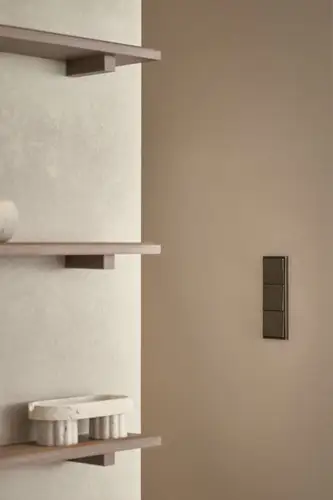 Push-button in the LS 990 programme in antique brass, ambience shot at GoodPost Studio.