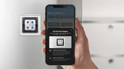 Matter Taster im Programm LS 990 in Alpinweiß in frontaler Ansicht auf einer Glasscheibe montiert. Handy im Vordergrund, scannt den QR-Code zur Installation.