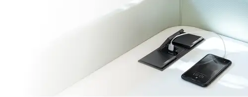 Steckdosen und USB-Ladegerät im Programm LS 990 in Schwarz. Ambienteaufnahme mit zum laden eingesteckten Smartphone