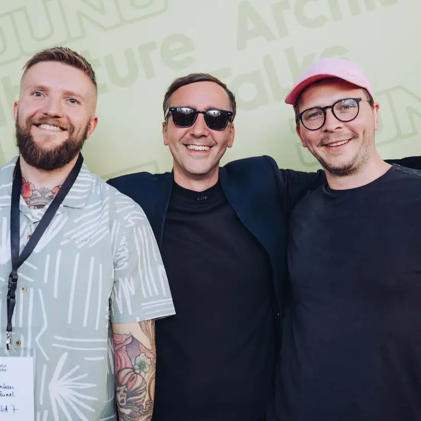 Architekturgespräche in Freiburg 2024, Besucher und Referent vor grünem Hintergrund