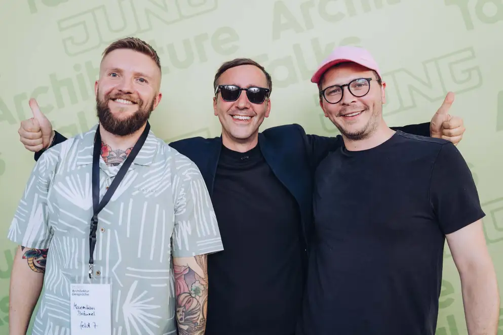 Architekturgespräche in Freiburg 2024, Besucher und Referent vor grünem Hintergrund
