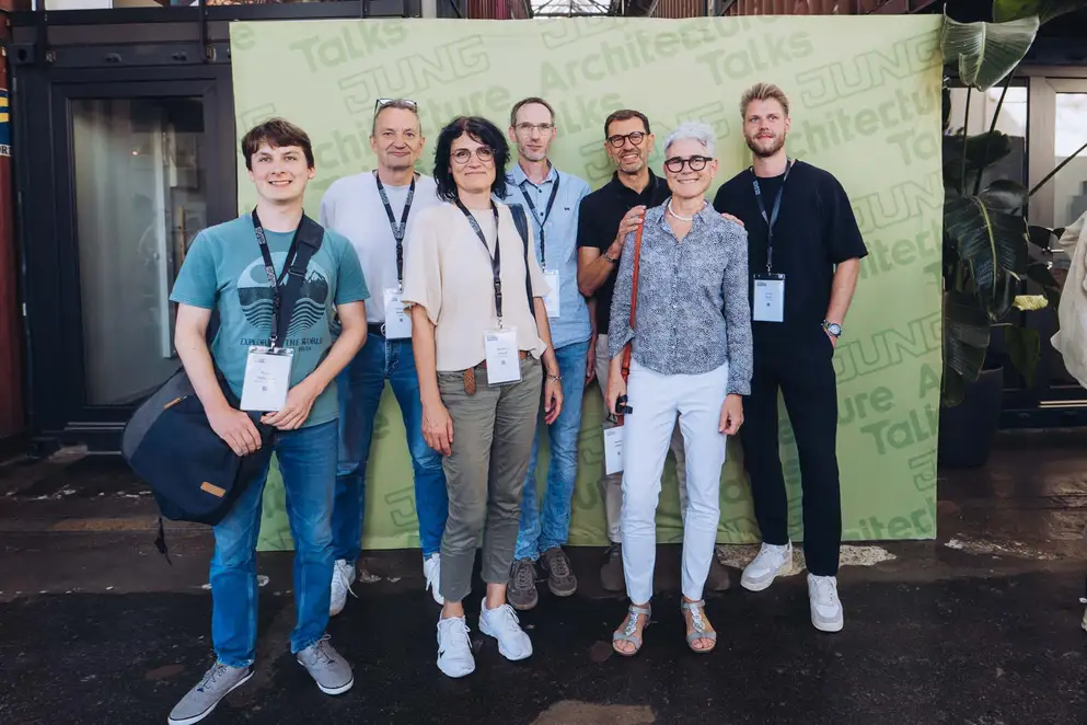 Architekturgespräche in Freiburg 2024, Besucherinnen und Besucher vor grünem Hintergrund