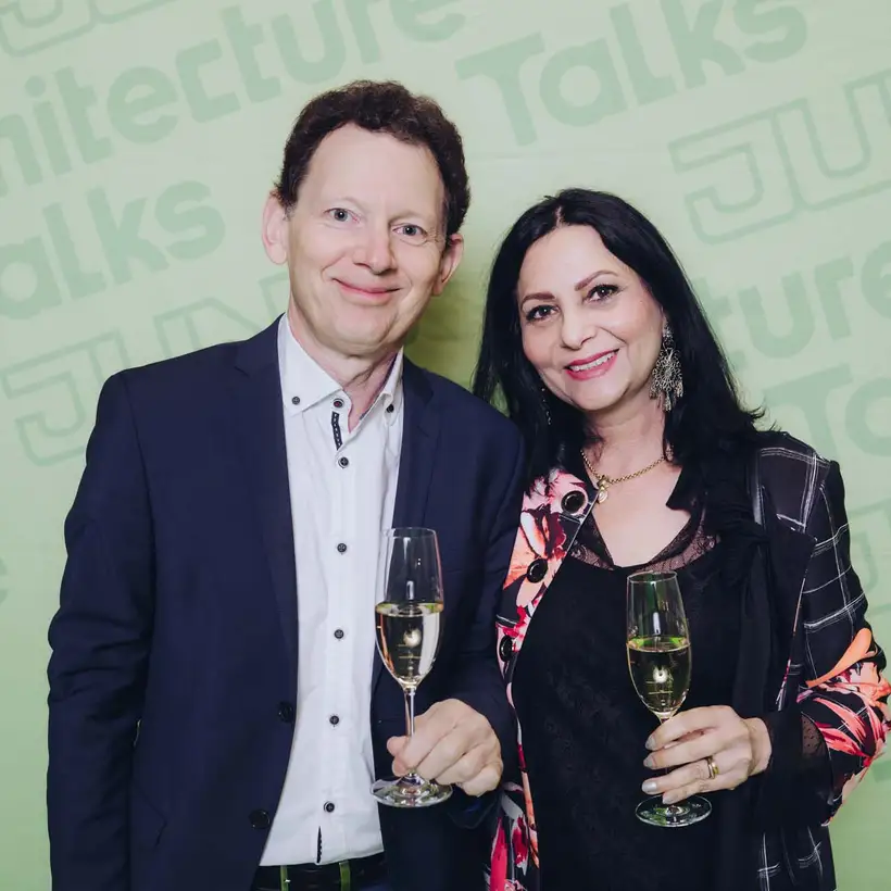 Architekturgespräche in Stuttgart 2025, Besucher und Besucherin vor grünem Hintergrund