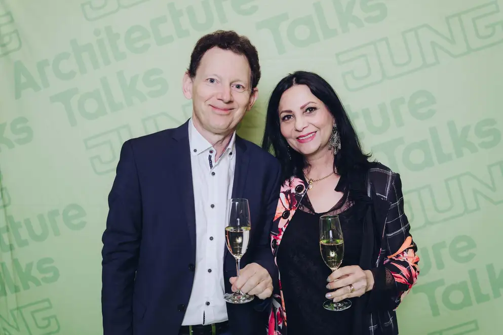 Architekturgespräche in Stuttgart 2025, Besucher und Besucherin vor grünem Hintergrund