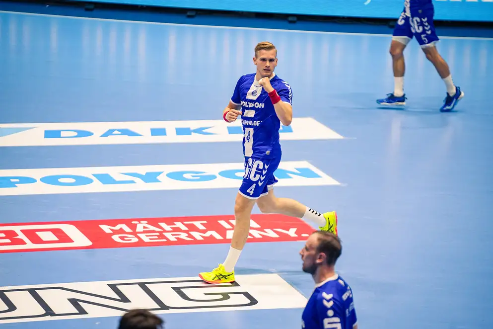 Ein Spieler des VfL läuft mit geballter Faust über das Spielfeld. Auf dem Boden sind verschiedene Sponsoren-Logos zu sehen.