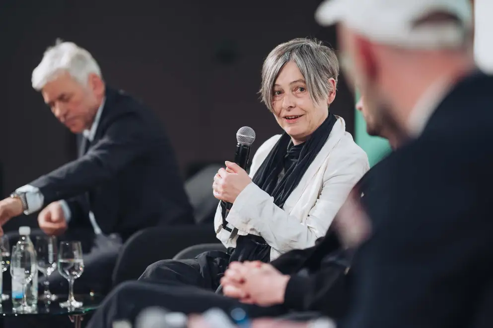 Architekturgespräche in Dresden 2025, Referentin spricht bei Podiumsdiskussion auf Bühne
