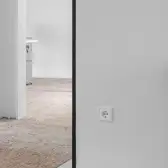 Eine LS 990 Steckdose in Alpinweiß montiert an einer Wand. 