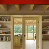 Innenansicht der renovierten Scheine. Ein Kind läuft hinter einer Glastür durch den Raum