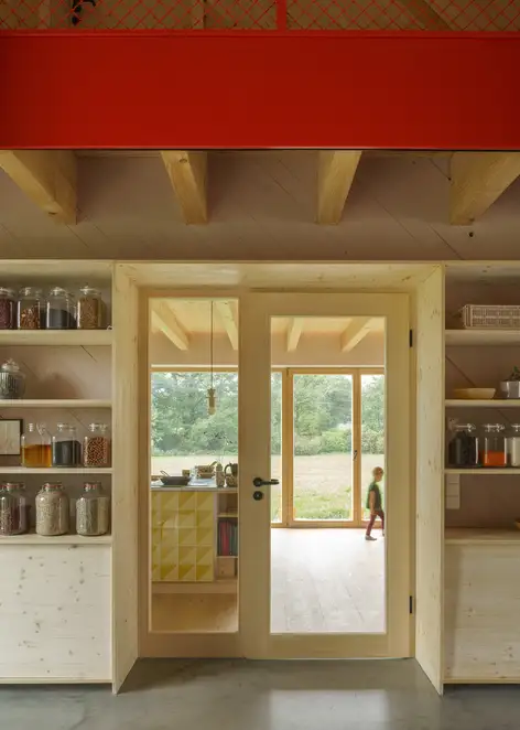 Innenansicht der renovierten Scheine. Ein Kind läuft hinter einer Glastür durch den Raum