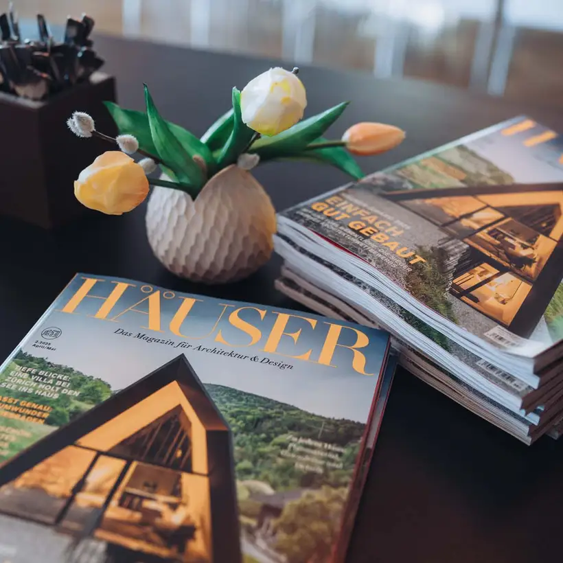 Elbgespräche 2025 / HÄUSER AWARD - Ein Stapel HÄUSER Magazine auf dunkler Ablagefläche