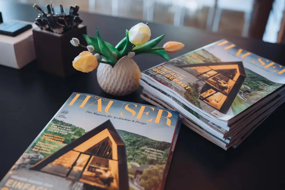 Elbgespräche 2025 / HÄUSER AWARD - Ein Stapel HÄUSER Magazine auf dunkler Ablagefläche