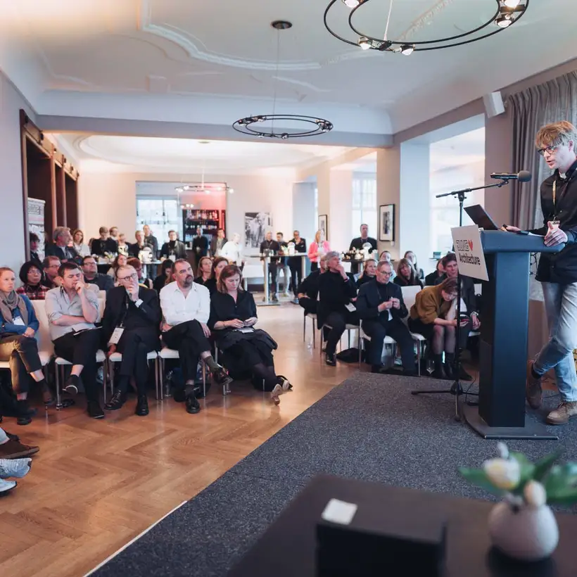 Elbgespräche 2025 / HÄUSER AWARD - Saalansicht mit Referent auf Bühne vor Publikum