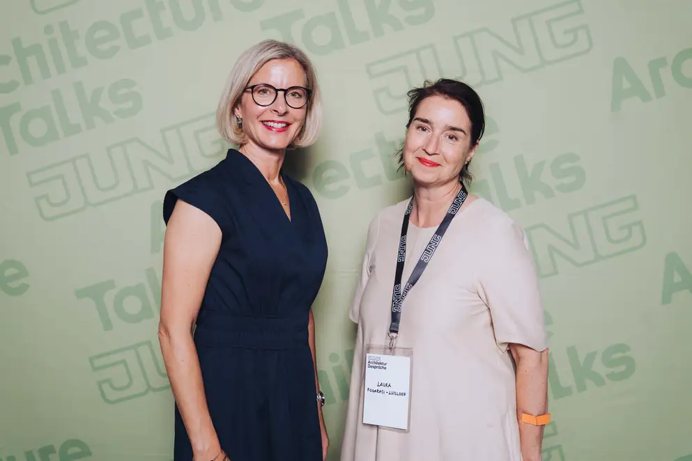 Architekturgespräche in Berlin 2025, Moderatorin und Besucherin vor grünem Hintergrund