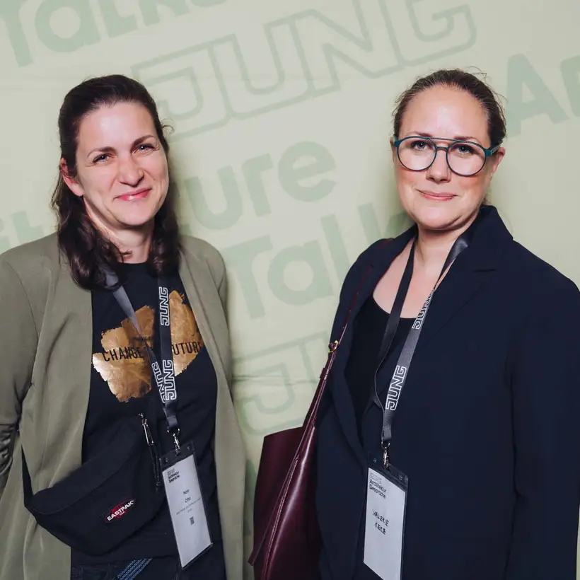 Architekturgespräche in Berlin 2025, Besucherinnen vor grünem Hintergrund