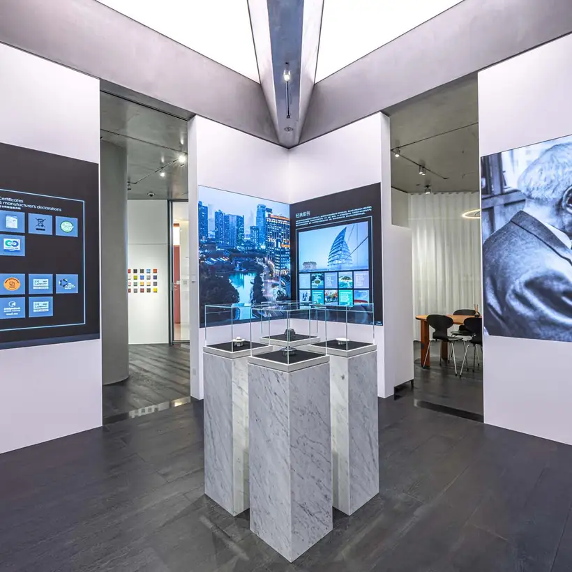 JUNG Showroom Cimen Shanghai / Ausstellungs-Räumlichkeiten mit zentral gehaltenen Produkt-Präsentationssäulen umgeben von großflächigen Fotos