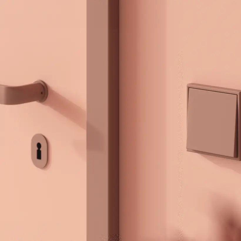 Lichtschalter im Programm LS 990 in Les Couleurs® Le Corbusier in leichter Perspektive. Detailaufnahme mit einer Tür im Anschnitt.