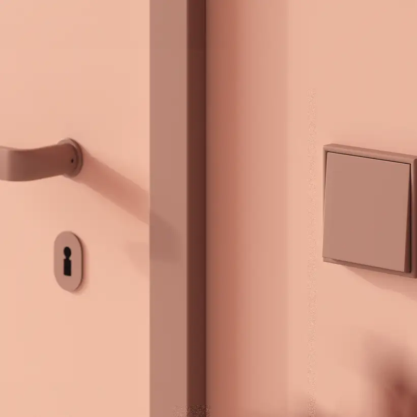 Lichtschalter im Programm LS 990 in Les Couleurs® Le Corbusier in leichter Perspektive. Detailaufnahme mit einer Tür im Anschnitt.