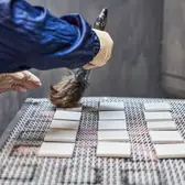 Metallverarbeitung und Handwerkskunst bei JUNG, Zunächst werden alle Partikel und Staubkörner unter fließendem Wasser entfernt.