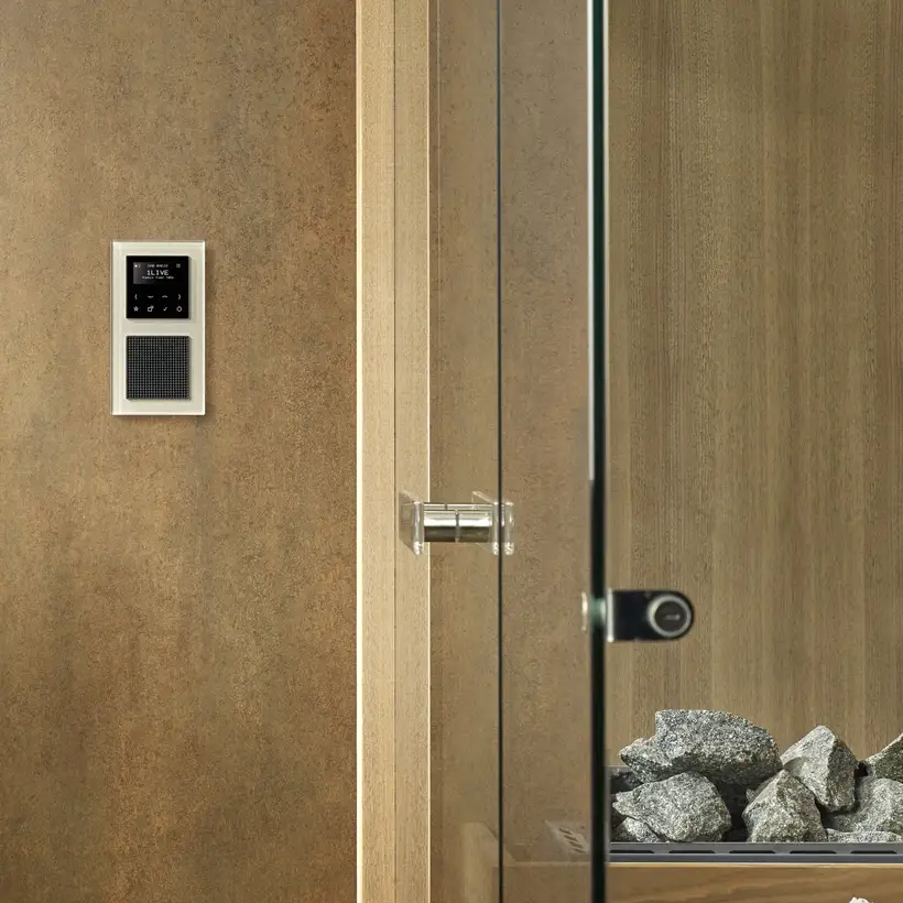 Digitalradio in der Serie A Creation aus Glas in Champagner, frontal aufgenommen, neben einer modernen Glassauna.