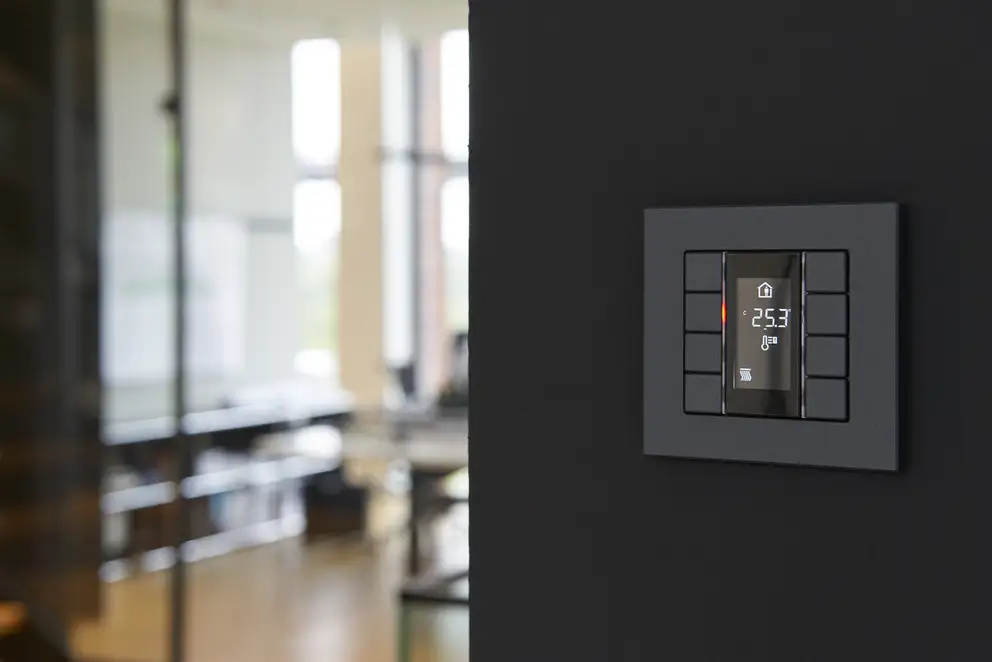 Taster F 50 für KNX und eNet SMART HOME als 4fach Taster, Detailaufnahme in einem schwarz gestrichenem Durchgang, durch geringe Tiefenschärfe hat der Hintergrund eine starke Unschärfe.