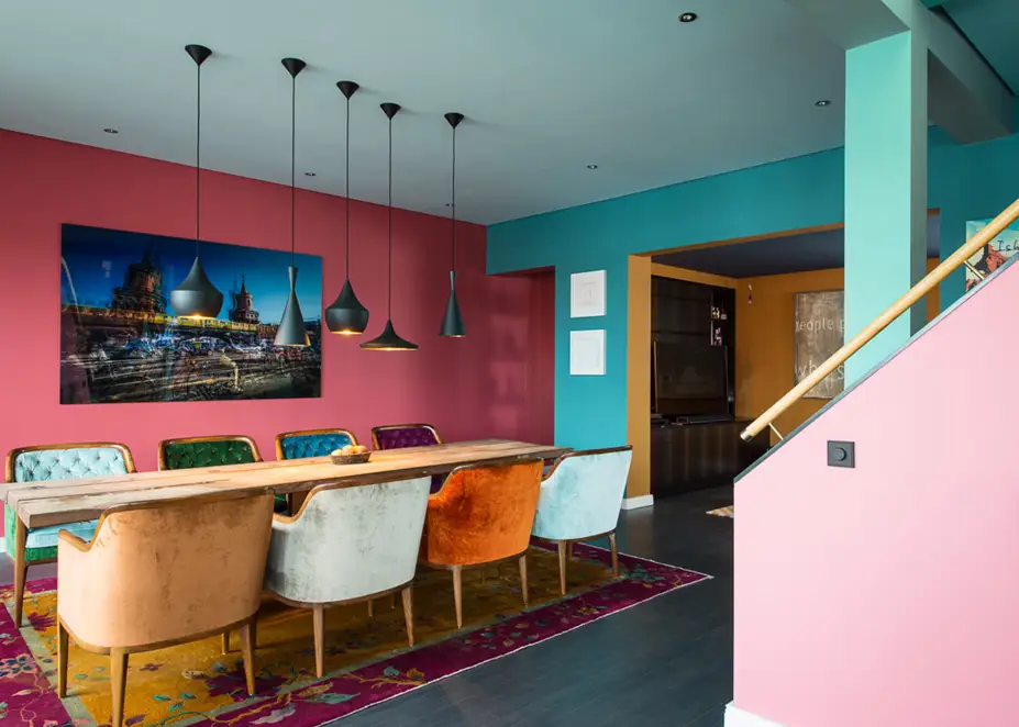 Drehdimmer im Programm LS 990 in Les Couleurs® Le Corbusier universellem Farbsystem, leicht perspektivisch und im Weitwinkel auf einem rosa Treppenaufgang fotografiert. Ambienteaufnahme Le Corbusier Arpartment Bambergerstraße, Berlin.