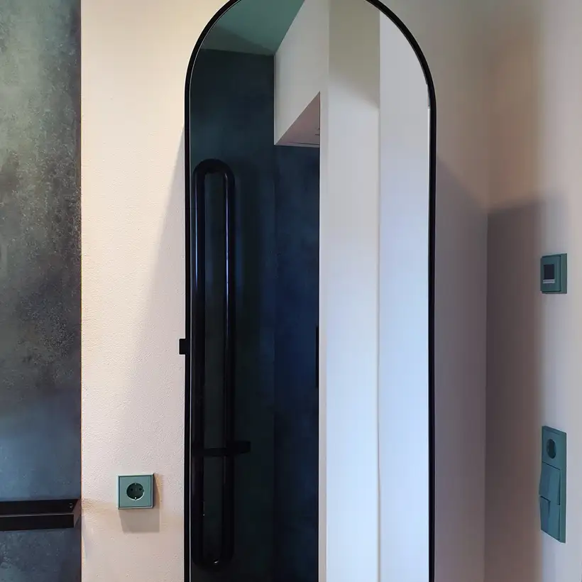 LS 990 Taster und Schuko Steckdosein Les Couleurs® Le Corbusier in 32041 vert anglais clair, fotografiert vor einer rosa Wand im Badezimmer,Raumausschnitt.