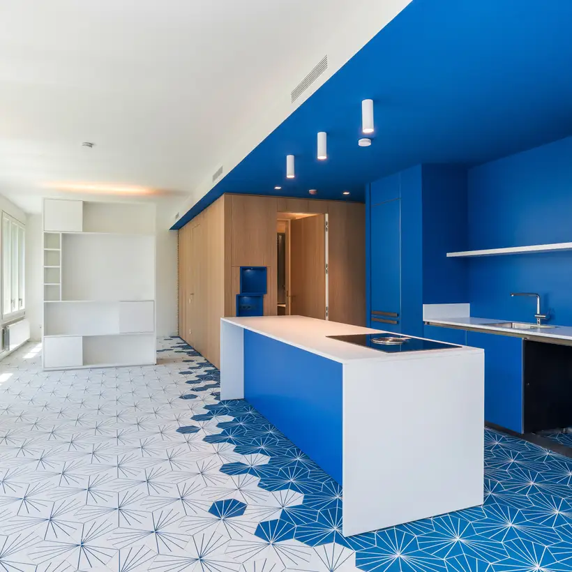 Ambienteaufnahme Referenzobjekt AM 41, Barcelona. Verschiedene Produkte in Les Couleurs® Le Corbusier universellem Farbsystem. Offener Küchenbereich, in weiß, blau und hellem Holz gehalten.