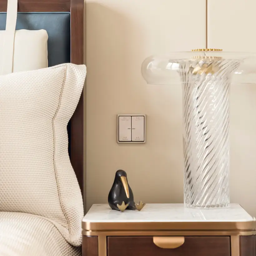 KNX Taster F 10 aus Edelstahl frontal fotografiert, über einem kleinen Nachtisch mit einer Ibis Statuette. Raumaufnahme aus einem Schlafzimmer im Sky Tower Shanghai.