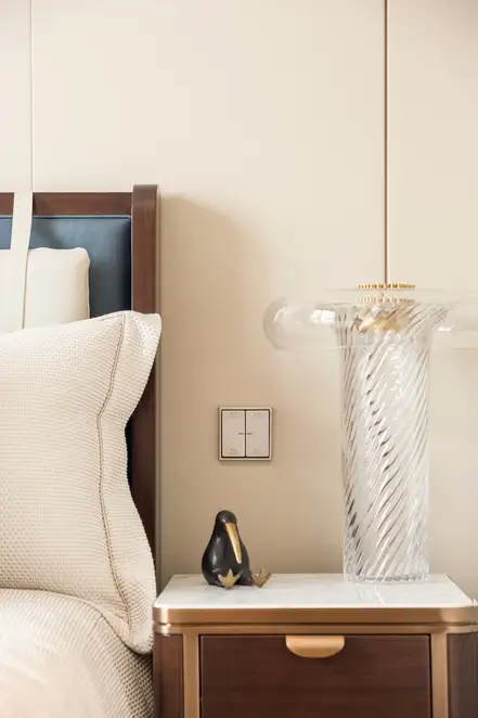 KNX Taster F 10 aus Edelstahl frontal fotografiert, über einem kleinen Nachtisch mit einer Ibis Statuette. Raumaufnahme aus einem Schlafzimmer im Sky Tower Shanghai.