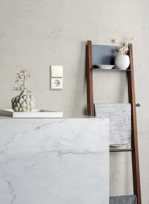 Tasterund SCHUKO® Steckdose im zwei-fach Rahmen im Programm LS 990 in weiß (Ivory). Ambiente Aufnahme in einem stilvollem Badezimmer.