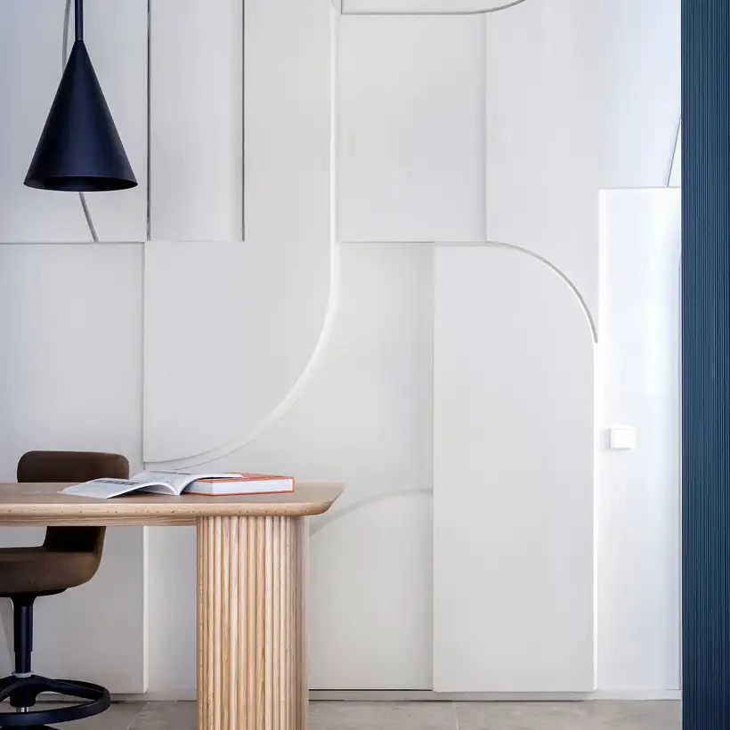 JUNG Brandstore Madrid, Schreibtisch im Anschnitt vor akzentuierter Wand